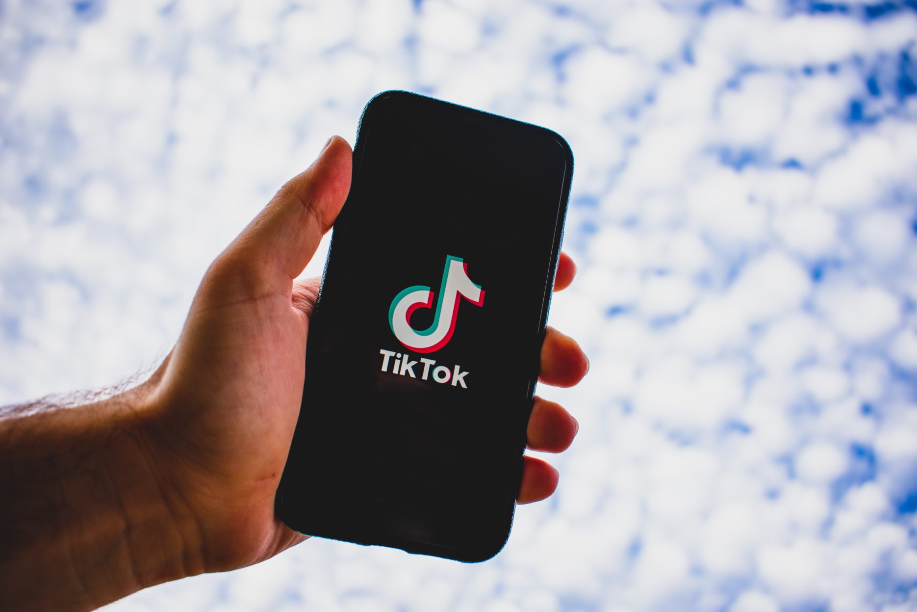 TikTok phone screen against clouds