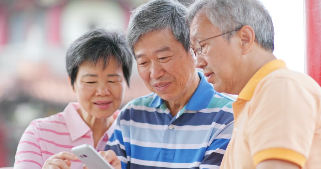 Elderly Chinese look at smartphone. Credit: Adobe Stock