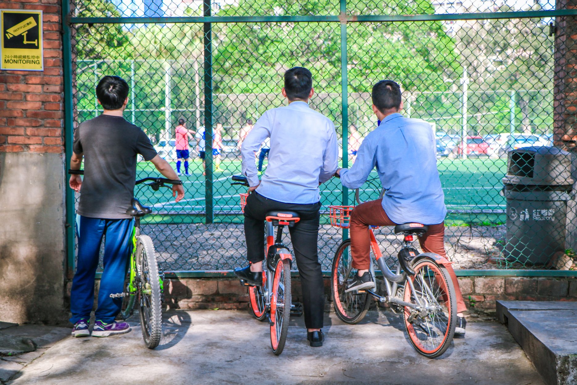 Cyclists watch football in China. Credit: Unsplash