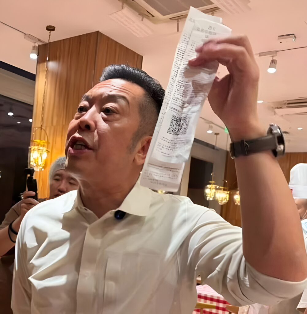 An enraged Jia Guolong brandishes a copy of Luo Yonghao's bill.